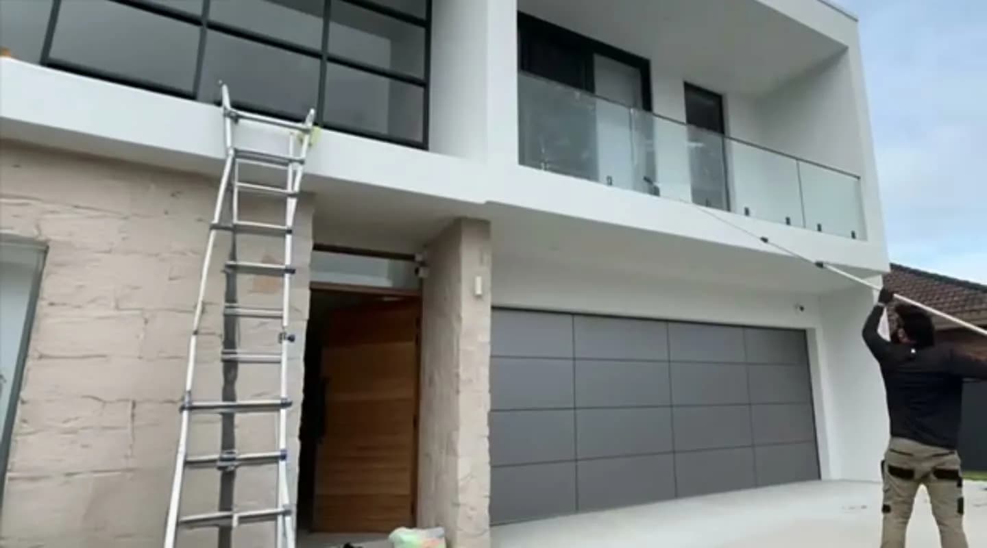 A Unique Business Co window cleaner at work on a Sydney shopfront