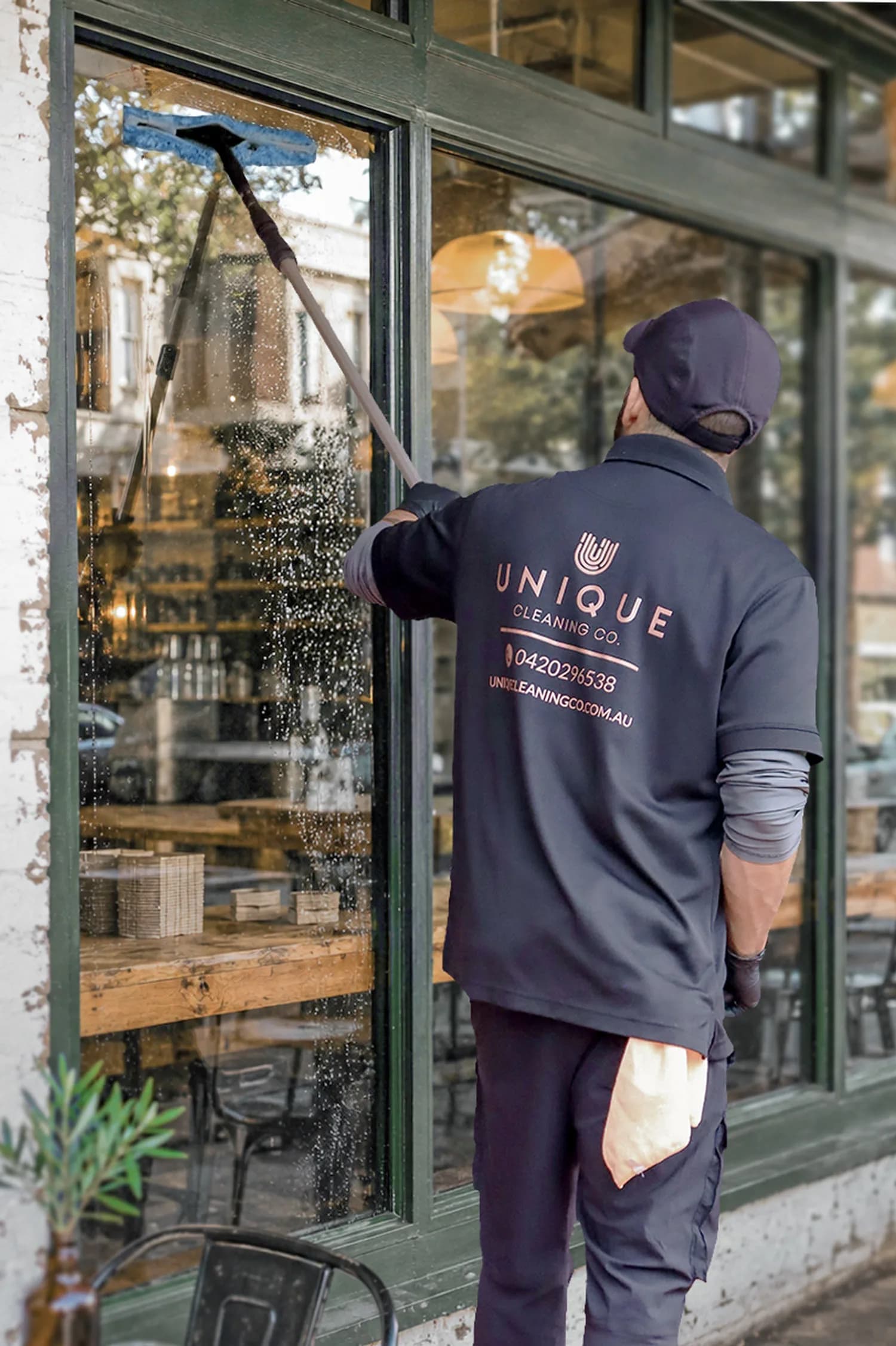 A Unique Business Co window cleaner working on a commercial building